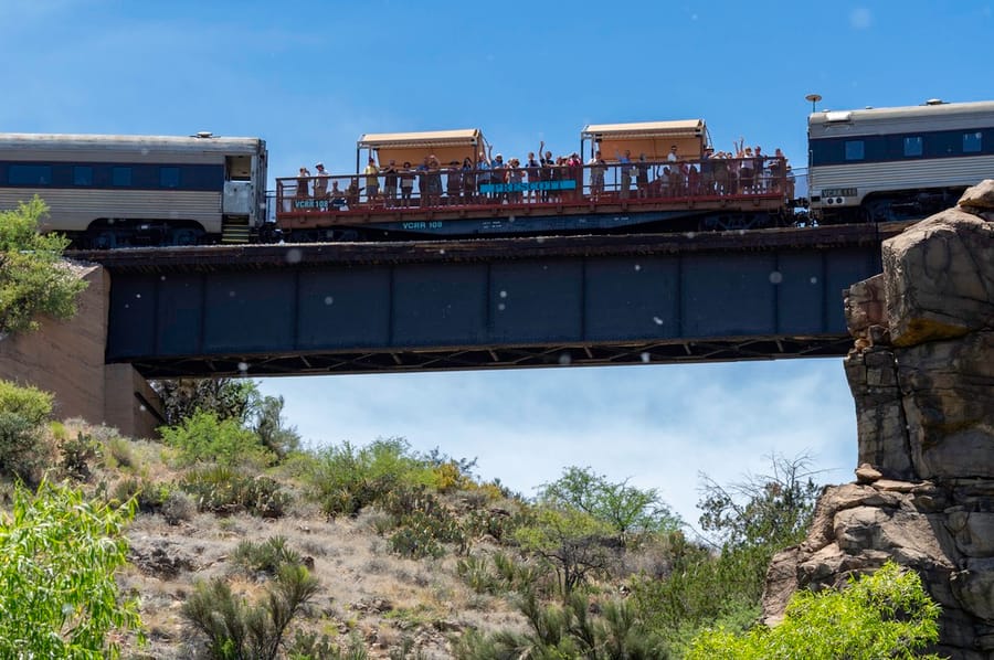 Clarkdale - Verde Canyon Railroad people waving in open air car_credit Kerrick James_05-21