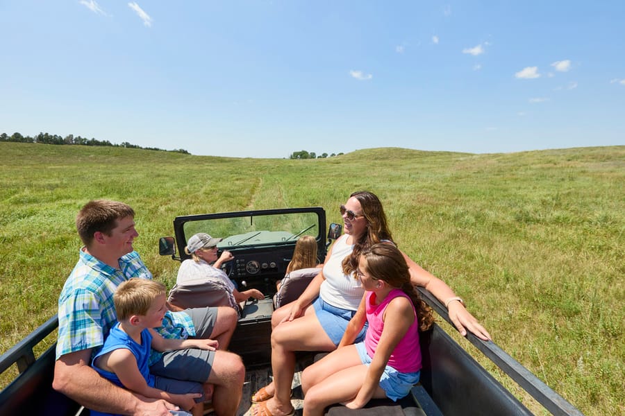 Calamus Outfitters_Family in Open Back Truck on Grassland_Clay Cook Shoot 2024