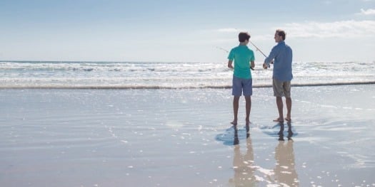 Dad and son fishing on beach in New Smyrna Beach