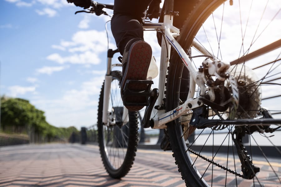 Woman riding bike at city on sunny day