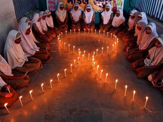 WEB School girls light candles in the shape of a ribbon during a HIV/AIDS awareness campaign ahead of World Aids Day, in Ahmedabad