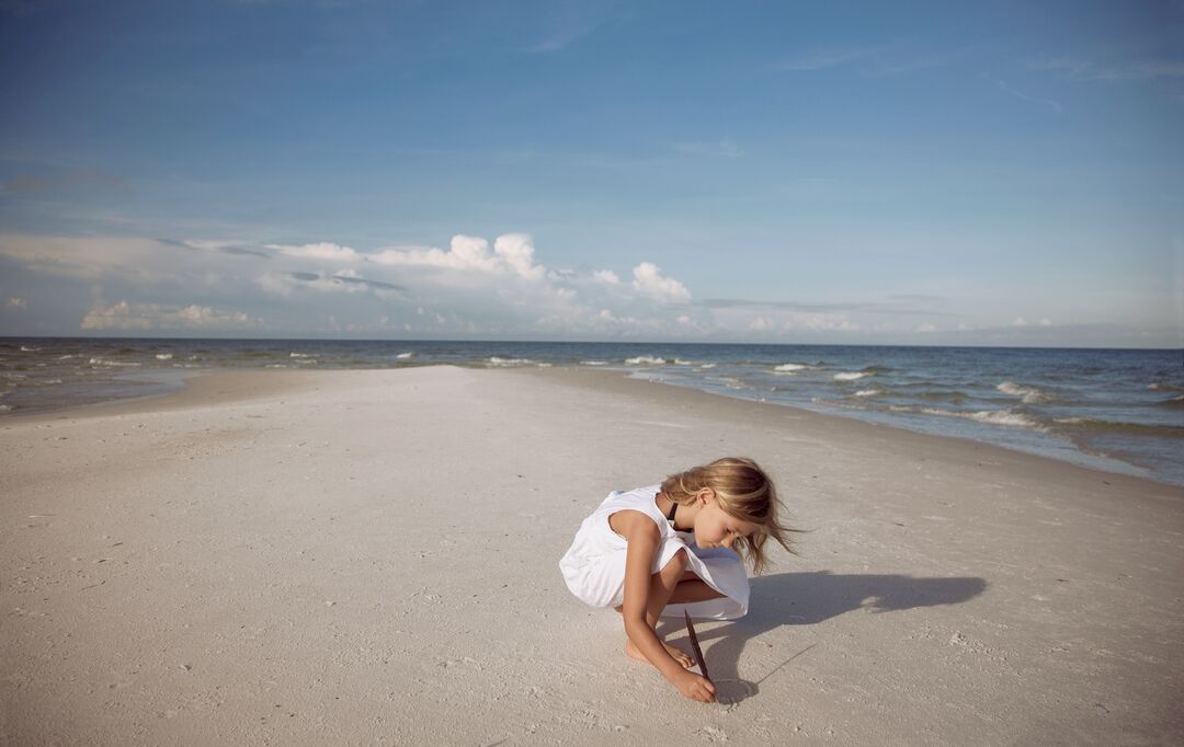 GIRL WRITING IN THE SAND ON AMI