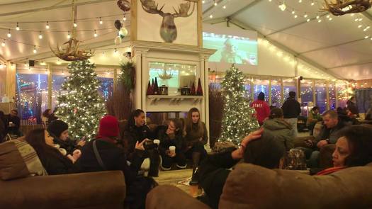 Winterfest - Slow travel left, wide - Inside pavilion, people sitting on couches