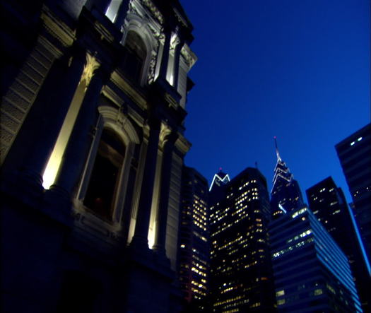 City Hall at night dutch angle pan to Liberty Place