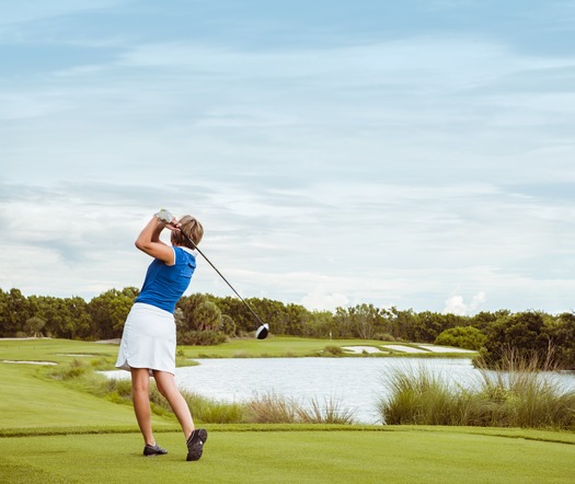 Woman Teeing off at Golf Course