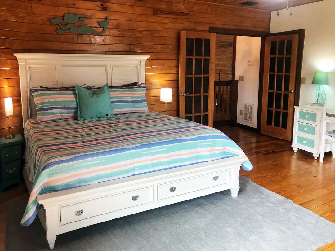 King bedded room with mermaid art